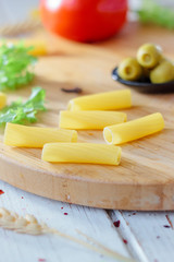 Italian tortiglioni pasta ready to cooking on kitchen board.