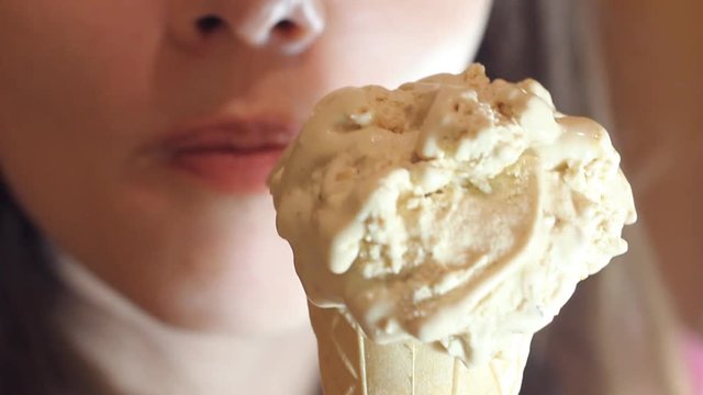 young beautiful sexy girl eats ice-cream / girl with a beautiful decollete sexy eating ice cream on a hot summer day