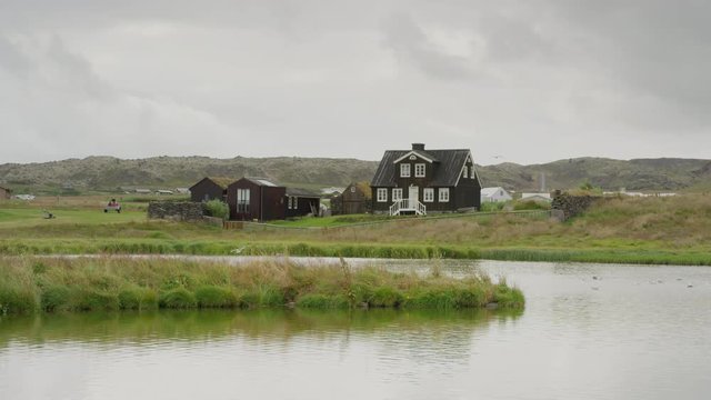 Wide shot of rural farm house near river. Arnarstapi, Snaefellsnes, Iceland