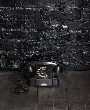 Black ancient phone on a black table