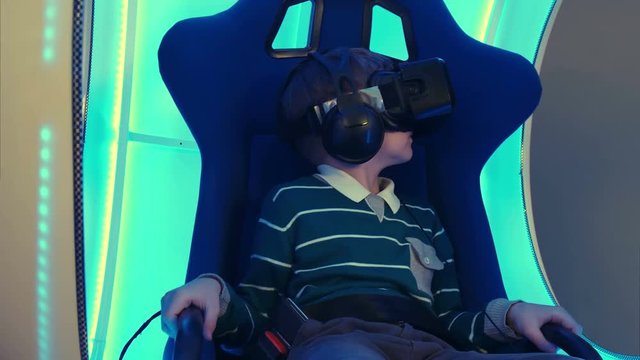 Male child in virtual reality chair enjoying his experience