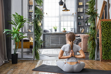 Woman practicing advanced yoga in the living room at home. A series of yoga poses