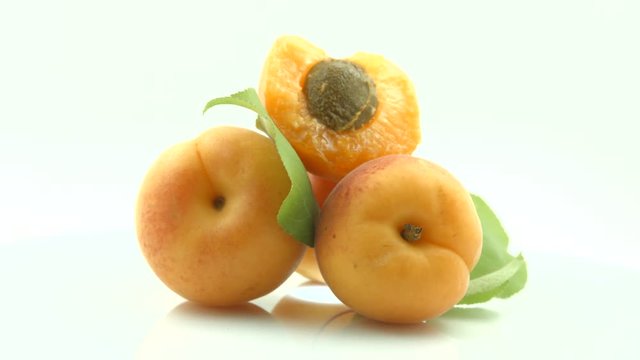 Apricots. Ripe organic apricot fruits isolated on white. Rotation 360 degrees. 4K UHD video 3840X2160