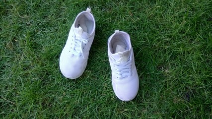 White sneakers on green grass