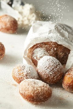 Doughnuts spilling out of bag with powdered sugar
