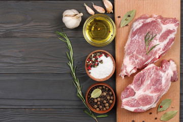 fresh raw meat with spices on wooden table. top view with copy space