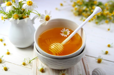 мед в керамической миске с ромашкой