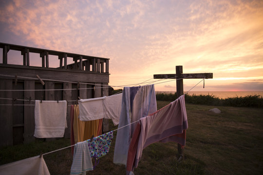 beach towels and laundry hung on a lin at sunset.