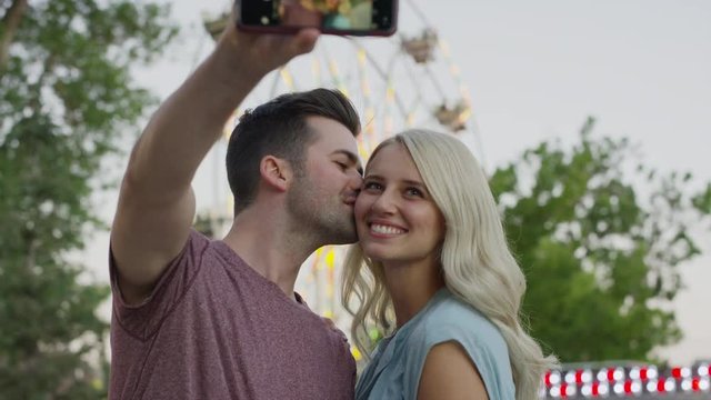 Close up of couple taking cell phone selfie at amusement park. Pleasant Grove, Utah, United States