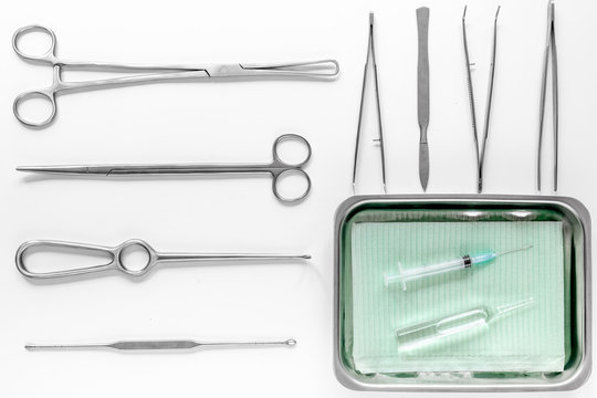Surgical instruments and tools including scalpels, forceps and tweezers on white table top view