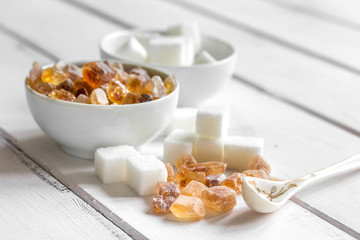variety of sugar in bowls on white wooden table background