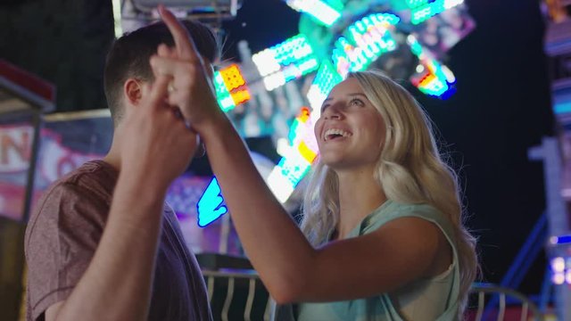 Close up panning shot of couple admiring amusement park at night. Pleasant Grove, Utah, United States