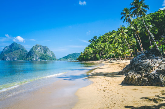 Sandy Beach with Palm Shadows, Huge Rocks in Background, El Nido, Palawan, Philippines