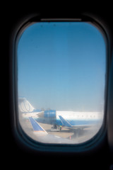 Photo of airplanes and blue sky seen through airplane window