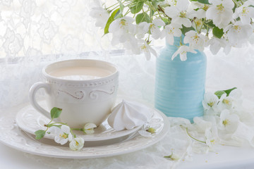 Still life with tea cup and blossom branch