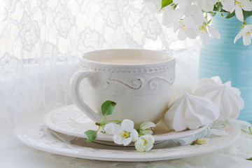 Romantic composition with tea cup, zephyr and apple flowers