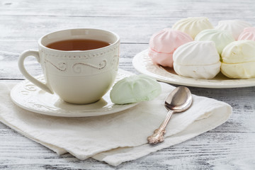 marshmallow or zefir dessert on white plate with branches of blooming apple