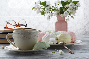 cup of tea with spring flower cherry blossom and old book on a wooden background