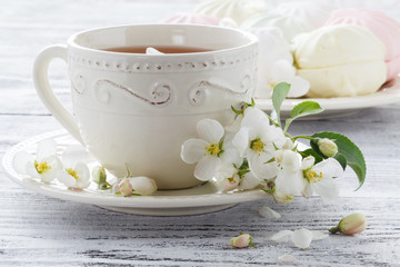 Fototapeta na wymiar Cup of green tea and japanese cherry blossom on blue background