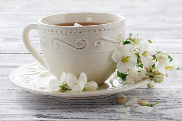 cup of tea with spring flower cherry blossom on a wooden rustic background