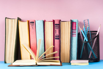 Open book, hardback books on bright colorful background.