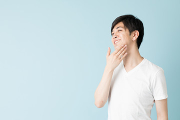 portrait of young asian man isolated on blue background