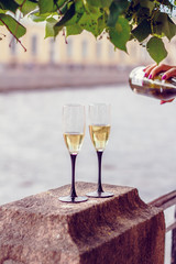 Bottle of champagne and two glasses on the embankment.