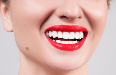 Obraz premium White teeth and red lips. Perfect female smile after whitening teeth.