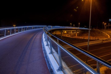 Fototapeta na wymiar Moderno puente de metal y hormigón iluminado en la noche