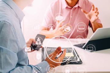 Fototapeta premium Businessmen working together on a document and using smart phone and digital tablet and laptop computer in modern office