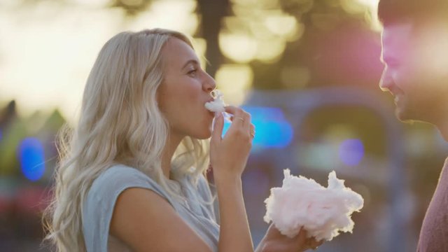 Close up panning shot of couple eating cotton candy and kissing. Pleasant Grove, Utah, United States