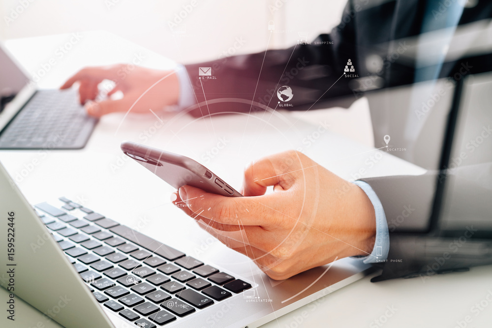 Aufkleber Hands of businessman using mobile phone in modern office with laptop and digital tablet computer with VR icon diagram