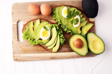 Sandwich with avocado and poached egg - healthy breakfast concept