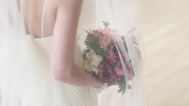 Beautiful bride is holding a wedding colorful bouquet