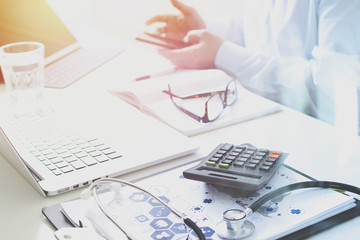 Healthcare costs and fees concept.Hand of smart doctor used a calculator for medical costs in...