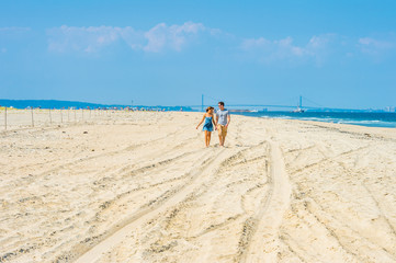 Fototapeta na wymiar Young couple walking, talking, relaxing on the beach in New Jersey, USA.