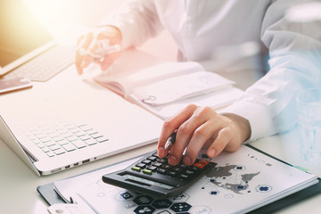 Healthcare costs and fees concept.Hand of smart doctor used a calculator for medical costs in modern hospital