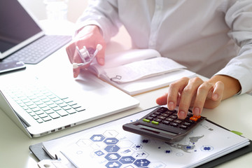 Healthcare costs and fees concept.Hand of smart doctor used a calculator for medical costs in modern hospital