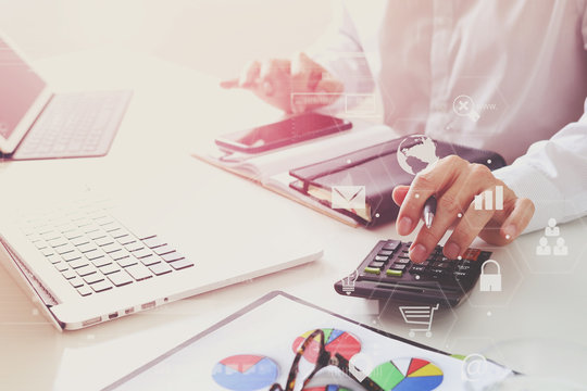 businessman hand working with finances about cost and calculate  and latop with mobile phone on withe desk in modern office