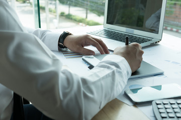 young graphic designer working with computer. creative man using digital tablet and stylus pen at...