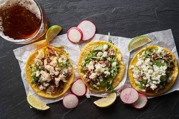 beer and carne asada mexican tacos with queso fresco cheese shot in top down composition