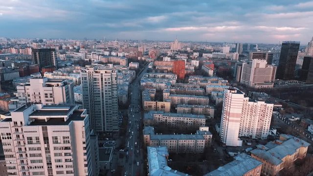 Aerial view of dormitory city area multistory living buildings in setting sun light, road car traffic