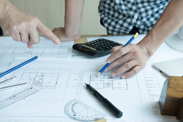 Architect working on real estate project with partner at workplace. Male engineer hand discussing with colleague on living house blueprint at office. Business, people, construction 