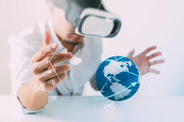 businessman wearing virtual reality goggles in modern office with mobile phone using with VR headset with all technology world network diagram element by NASA
