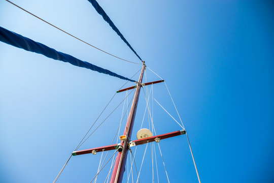 The rolled sail is attached to a tall mast. Preparation for departure to the open sea.