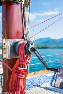 The winch is attached to the red mast of the yacht. Preparation for departure to the open sea.