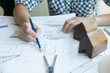 Architect working on real estate project at workplace. Male engineer hand working with living house blueprint at office. Business, people, construction and building concept