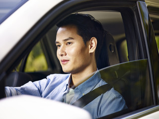 young asian man driving a car