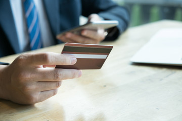 male holding a credit card and using laptop computer for online shopping. businessman purchase goods from internet. man make payment on bank website