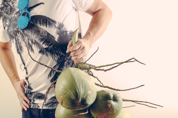 Summer and holiday fashion concept.Man Wearing palm trees graphics on T-shirt and holding cluster of coconuts with items on white background